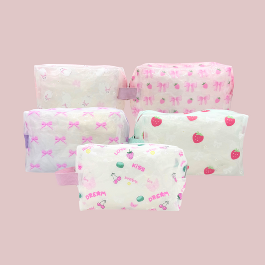 Five small pouches with colorful patterns on a pink background
