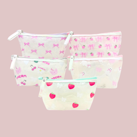 Set of three clear pouches with printed designs on a pink background